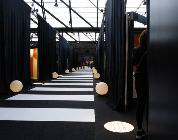 Black and White Carpet in stripe pattern next to black drapes hanging from glass ceiling