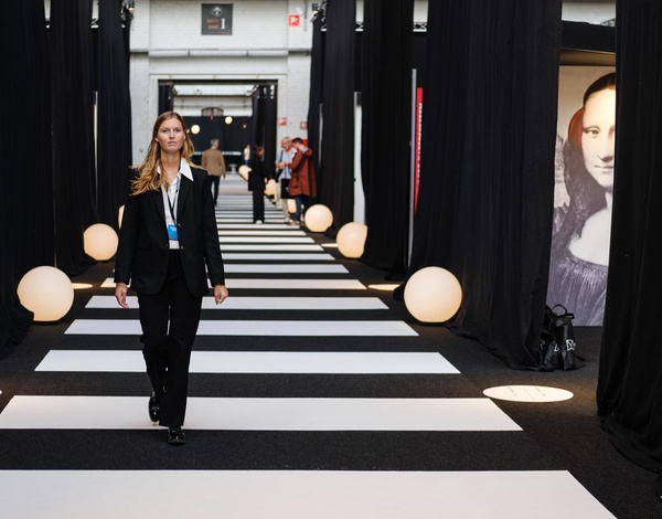 Woman in suit walking on sustainable event carpet black and white colour in stripe pattern in big event hall 