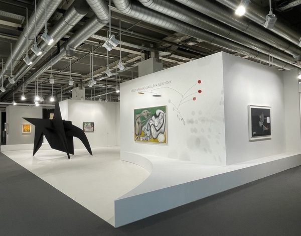 white art exhibition stand with black sculpture on left side, paintings on white walls, and dark event carpet flooring
